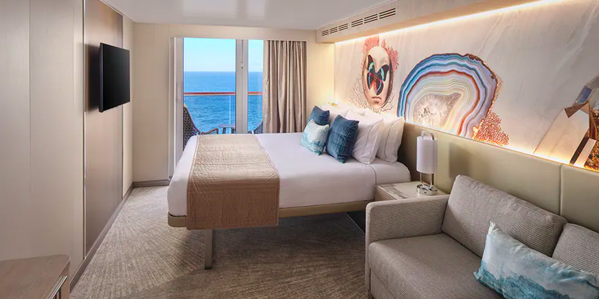 Cruise stateroom with a balcony, decorated in a neutral white and beige color scheme