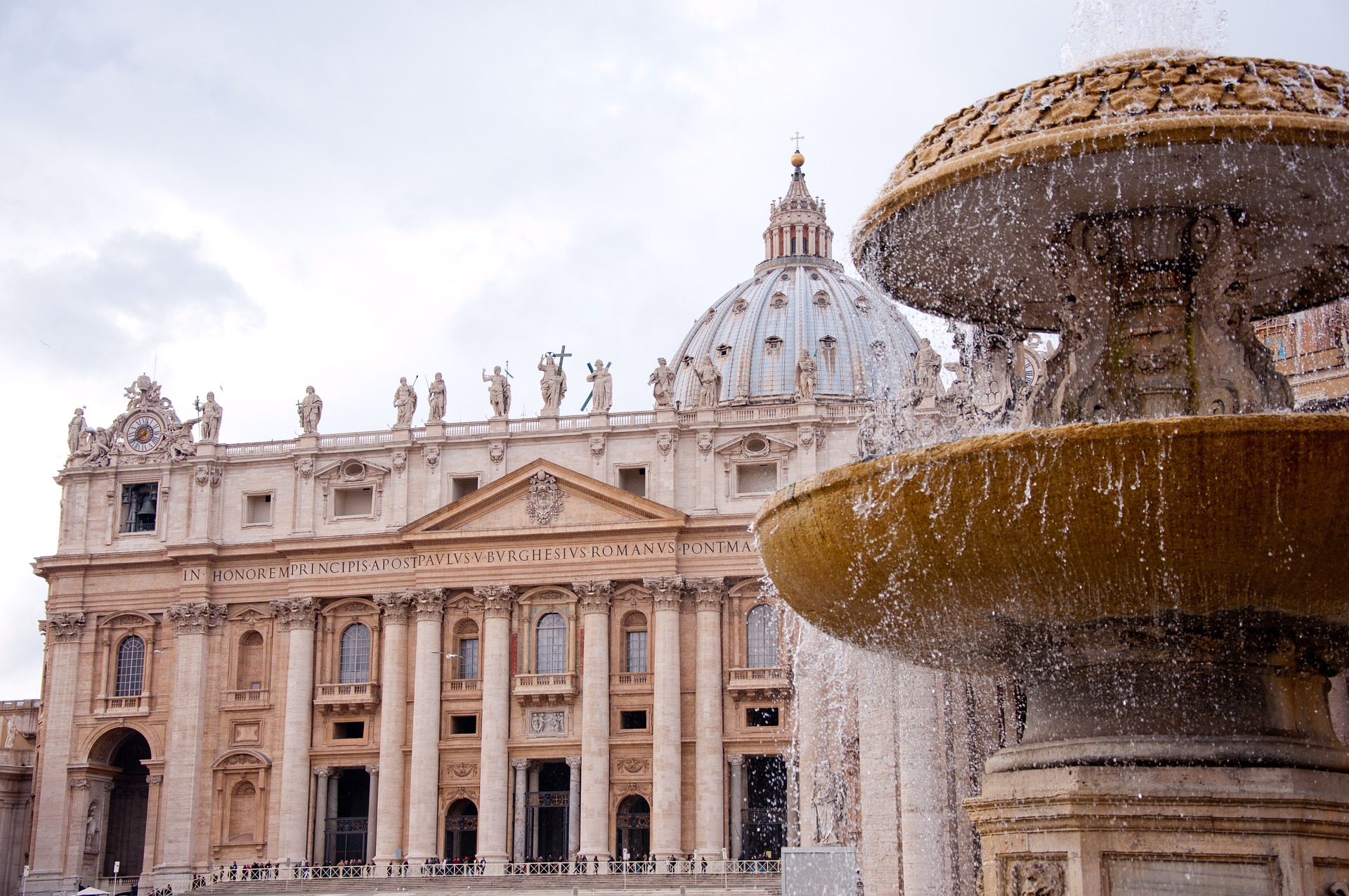 The front of St. Peter's Basilica in Vatican City with a large fountain in front
