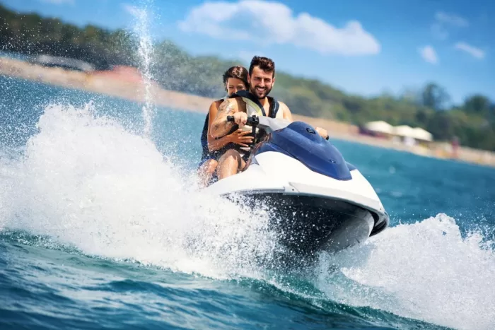 A coupe riding a jet ski