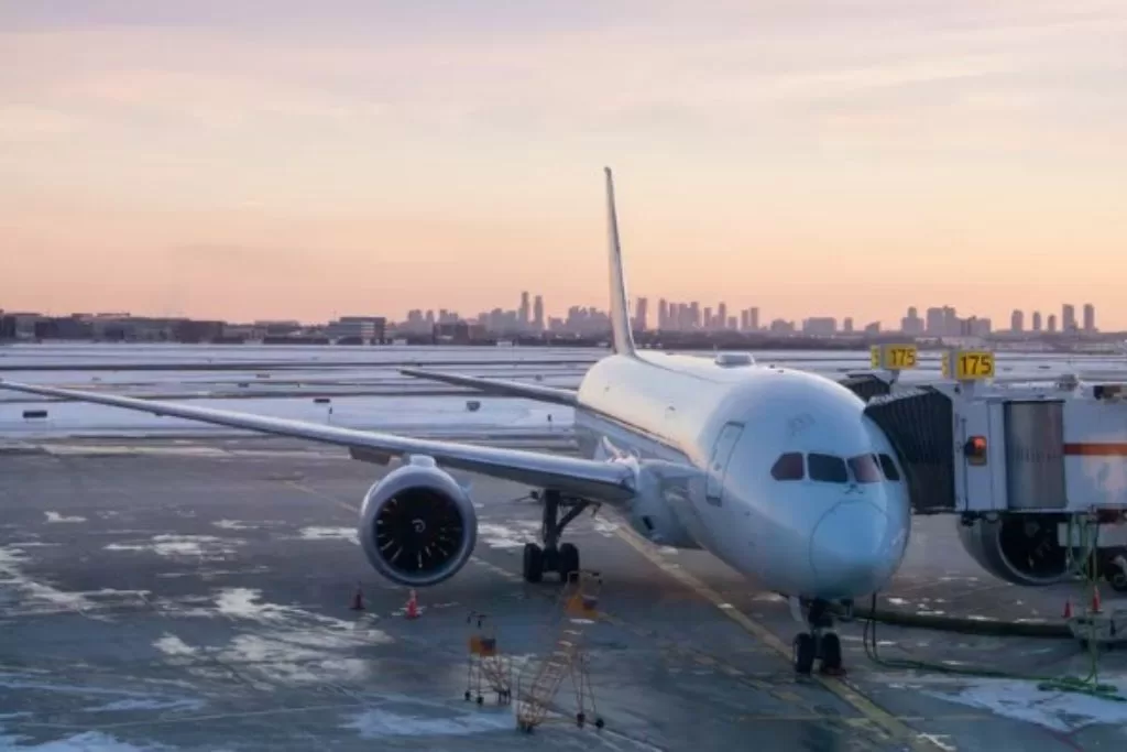 An airplane loading passengers while sitting on a snowy tarmac